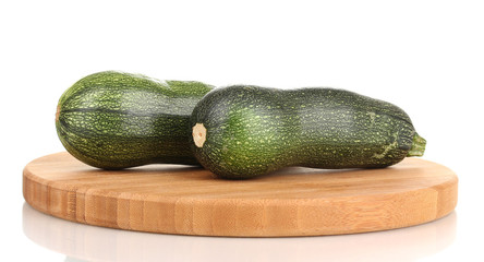 Fresh zucchini on chopping board isolated on white