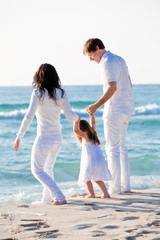 Fototapeta na wymiar glückliche junge familie mit kleiner Tochter am Strand am wasse
