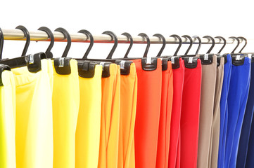 colorful female trousers on hangers