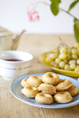 plates of pastries and biscuits and tea pot on wooden table