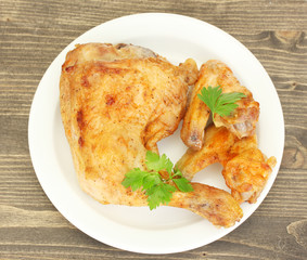 roasted chicken wings and leg with parsley in the plate