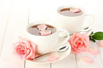Fototapeta na wymiar filiżanki herbaty z róż na białym drewnianym stole