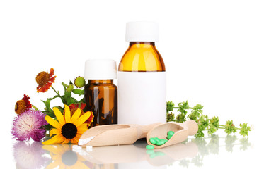 medicine bottles with tablets and flowers isolated on white