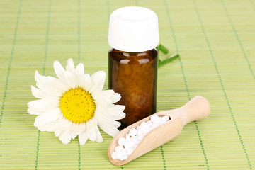 medicine bottle with tablets and flower on bamboo mat