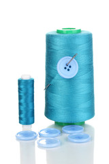 Blue bobbin with needle and buttons isolated on white