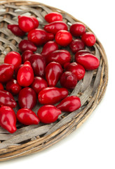 fresh cornel berries on wicker mat isolated on white