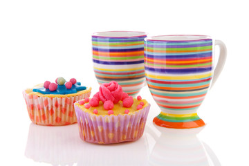 Decorated colorful cupcakes and cups of coffee