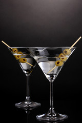 Martini glasses and olives on grey background
