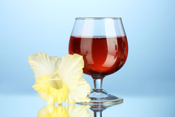 glass with cocktail and gladiolus bud