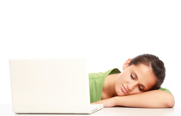 A young college girl sleeping in front of a laptop