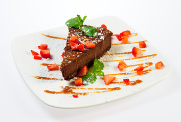 Slice of luscious chocolate pie with caramel and strawberries