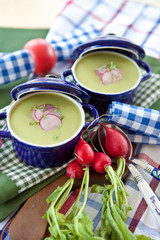 Zwei kleine blaue Töpfe mit grüner Suppe 