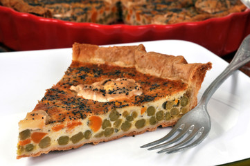 Part de tarte au chèvre, petits pois et carottes