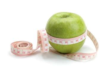 A green apple and a measuring tape