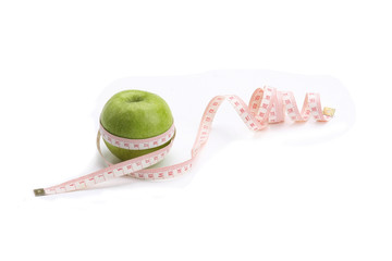 A green apple and a measuring tape
