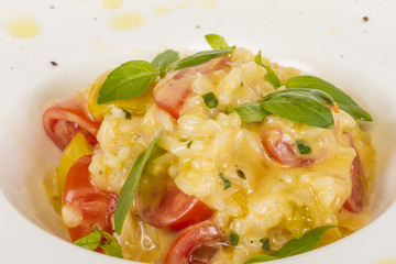 photo of delicious risotto dish with herbs and tomato on white b