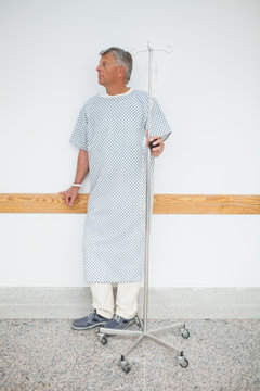 Man Standing Against The Wall With His IV Drip