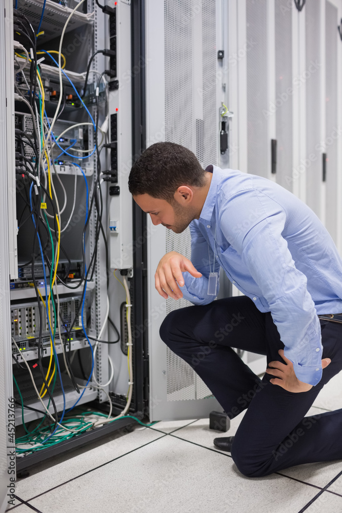 Aufkleber technician looking at cables of the server