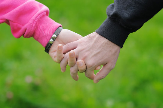 Detailed view of a young couple holding hands