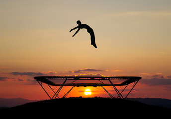gymnast on trampoline in sunset - 45217174