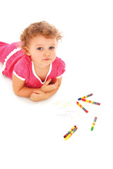 A lovely child with pencils lying on the floor