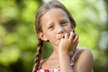 Cute girl licking off chocolate fingers.