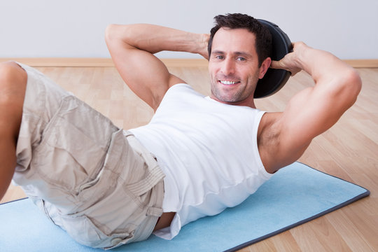 Young Man Exercising On Exercise Mat