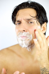 Man touching blood wound after shaving