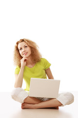 A young girl sitting on the floor with a laptop