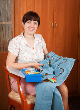 Woman shows   cloth beaded by herself
