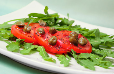 Salad with fresh tomatoes, capers and arugula