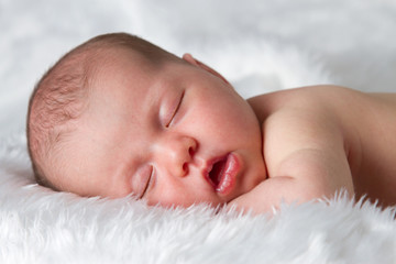 Sleeping newborn baby asleep on fluffy blanket