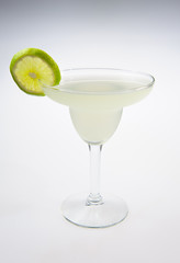 Alcohol cocktail with lime over white background