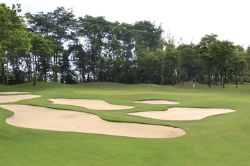 view of golf course showing green area protected by sand bunkers