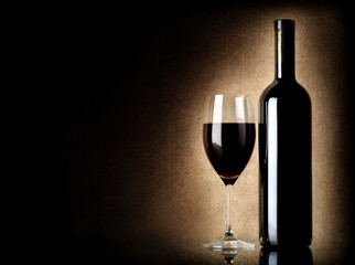 Wine bottle and wineglass on a old background