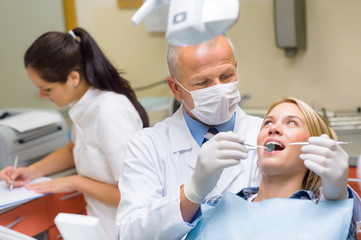 Dentist doing procedure on young patient woman