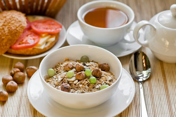 light breakfast with tea, fruit, sandwich and porridge