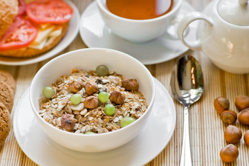 light breakfast with tea, fruit, sandwich and porridge