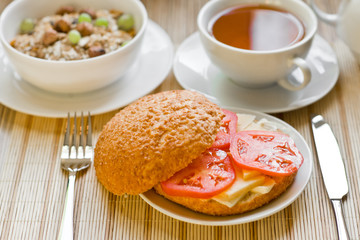 light breakfast with tea, fruit, sandwich and porridge