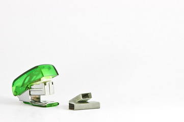Green stapler with a bunch of staples
