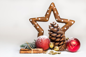 Weihnachts-Deko mit Kugeln, Zapfen, Stern und Zimtstangen