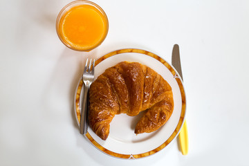 Breakfast with croissant and orange juice on dish