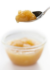 Apple jam  on spoon isolated on white background