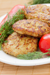 Close up of meatballs with dill and tomatoes on a plate