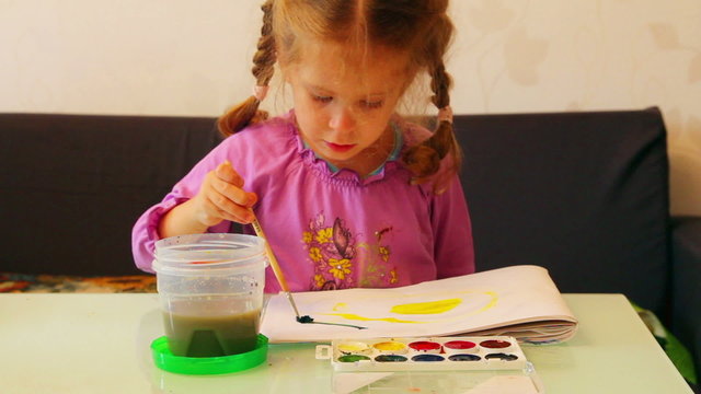 little girl draws paints