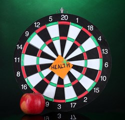 Darts with a sticker symbolizing health on colorful background