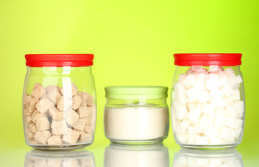 Jars with brown cane sugar lump, white crystal sugar and white