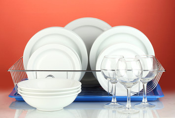 clean dishes on stand on red background