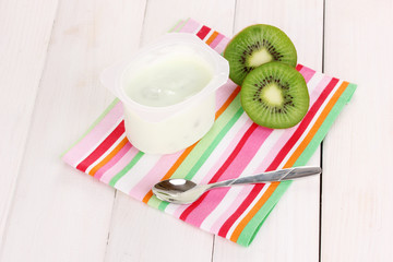 yogurt with kiwi on napkin on wooden background