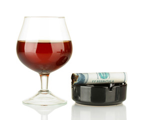 Cigar of the 100 dollar bill and an ashtray and glass of brandy